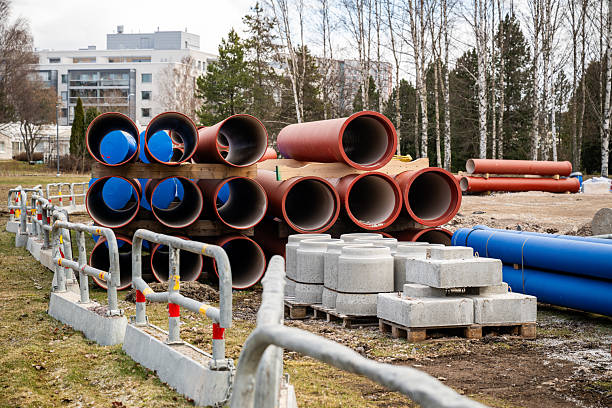 Red construction pipes stacked on wooden pallets at a construction site Red construction pipes stacked on wooden pallets at a construction site