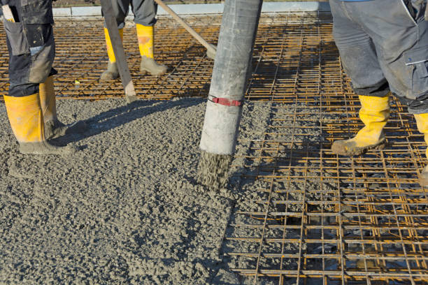 Construction worker pours concrete on rebar using concrete pump Construction worker pours concrete on rebar using concrete pump