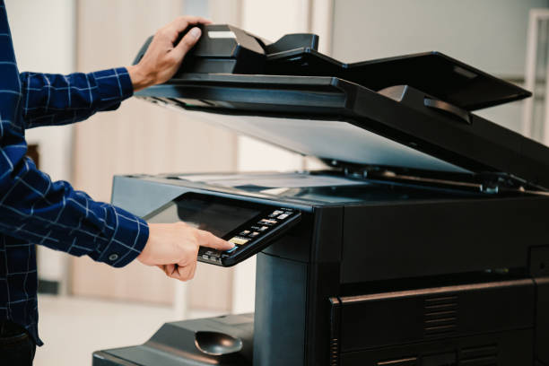 Copier printer, Close up hand office man press copy button on panel to using the copier or photocopier machine for scanning document printing a sheet paper.