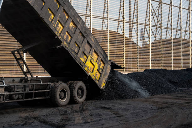 Trucks loading and unloading at large coal yard yards Trucks loading and unloading at large coal yard yards