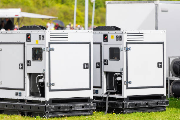 Set two large portable industrial power fuel generator green lawn at commercial event outdoors clear blue sky background. Mobile electricity supply energy plant unit backup equipment rent service.