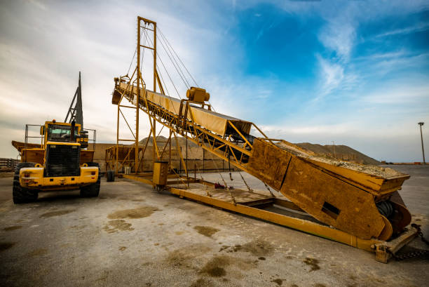 ore belt conveyor and yellow bulldozer excavator on industrial job site ore belt conveyor and yellow bulldozer excavator on industrial job site