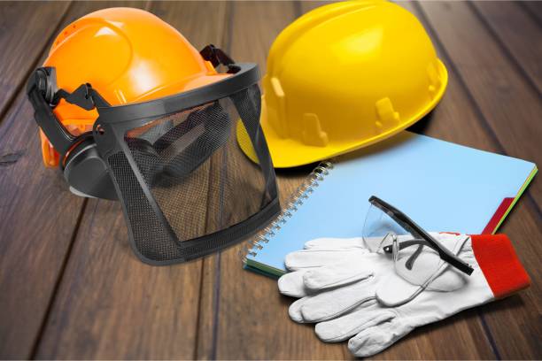 Yellow helmet with equipment on wooden background Yellow helmet with equipment on wooden background